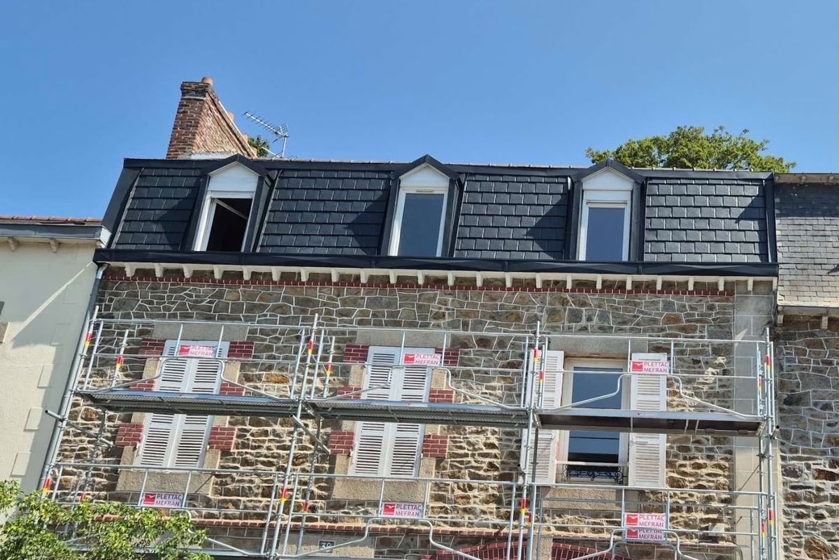 Immeuble en pierre dont la toiture est refaite en aluminium, échafaudage dressé en façade