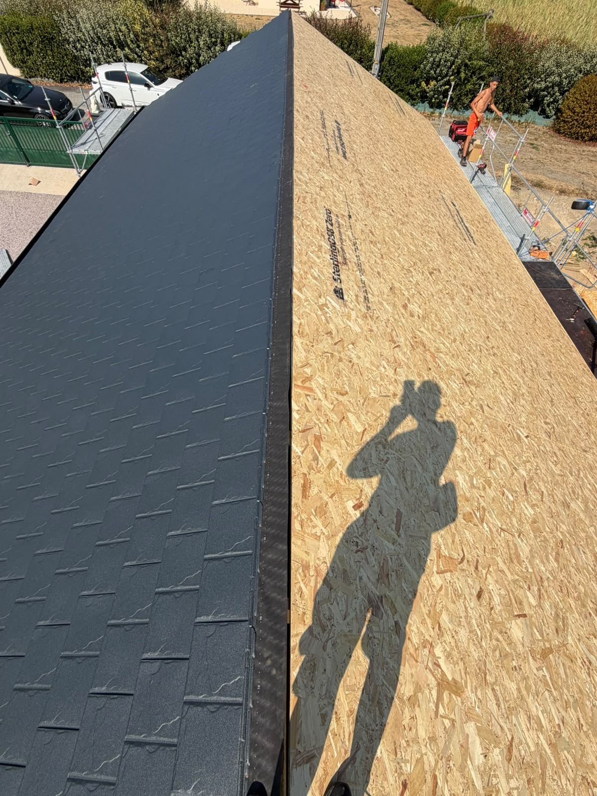 Pose de tuiles aluminium en cours sur un support en panneaux de bois
