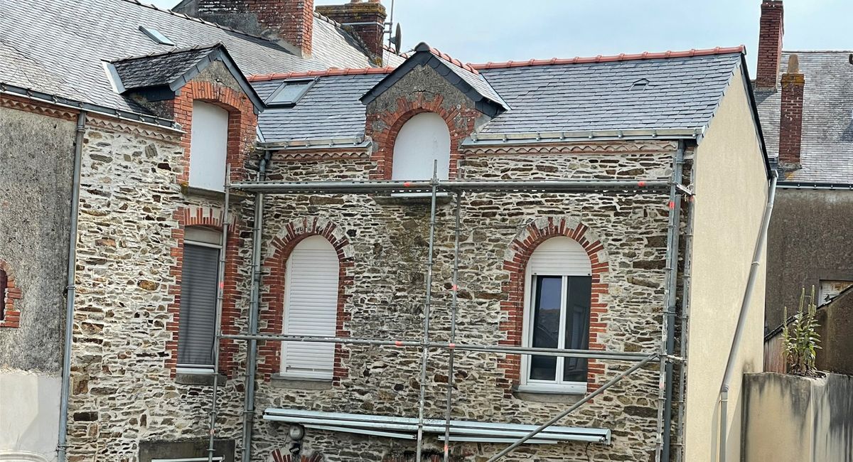 La même maison en pierre avec sa toiture en ardoise refaite à neuf
